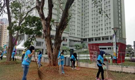 Para volunteer Asian Games 2018, tengah sibuk membersihkan taman di Wisma Atlet, Kemayoran, Selasa (7/8) sore. 