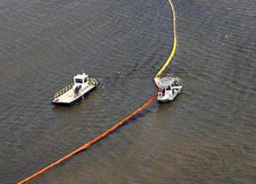 Para petugas di Teluk Meksiko menggelar alat pembendung tumpahan minyak dekat Port Eads, Louisiana guna mencegah pencemaran zat-zat kimia , 29 April 2010.