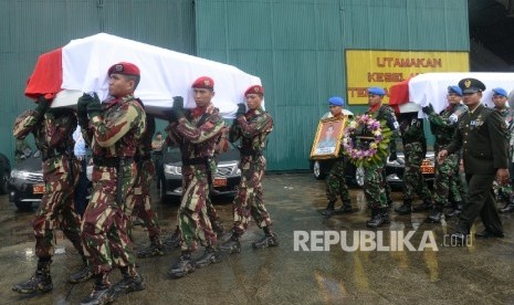 Parajurit TNI dan Polri membawa peti ke dalam Mobil Jenazah saat upacara pelepasan jenazah korban Helikopter TNI AD jenis Bell 412 EP di Hanggar Skadron Udara 17 Lanud Halim Perdanakusuma, Jakarta, Selasa (22/3).