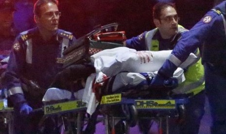 Paramedics remove a person, with bloodstains on the blankets covering the person, on a stretcher from the Lindt cafe, where hostages were being held, at Martin Place in central Sydney December 16, 2014.