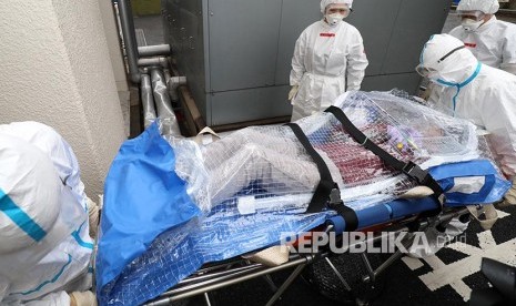 Paramedis membawa pasien terduga terpapar virus pada latihan menghadapi wabah di Rumah Sakit Metropolitan Komagume, Tokyo, (23/1). 