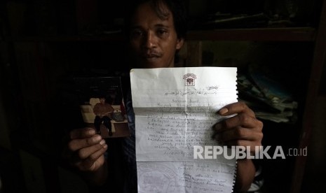 Parsin, the second child of Parinah, shows his mother's last photograph and letter asking help to return to Indonesia, in Petarangan village, Kemranjen, Banyumas, Central Java Province, on Monday (April 9). Parinah is an Indonesian migrant worker went missing for 18 years. 