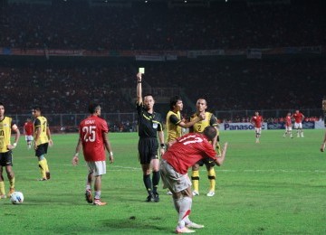 Partai Indonesia melawan Malaysia berlangsung ketet hingga banyak membuahkan kartu kuning bagi kedua kesebelasan, slah satu diterima oleh pemain Indonesia Ferdinan Sinaga, GBK Jakarta, Senin, (21/11). (Republika Online/Fafa)