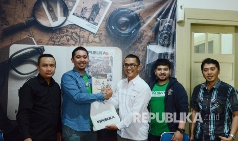 Partner Grab Jawa Barat Mawaddi Lubby (kedua kiri) menerima cinderamata buku terbitan Republika dari Kepala Perwakilan Republika Jawa Barat Rachmat Santosa Basarah saat berkunjung ke Kantor Republika Jawa Barat, Jalan Mangga, Kota Bandung, Kamis (25/7).