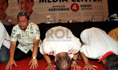 Pasangan Ahmad Heryawan-Deddy Mizwar beserta tim sukses melakukan sujud syukur di Media Center Aher-Deddy, Bandung, Jawa Barat, Ahad (24/2).  (Republika/Prayogi)