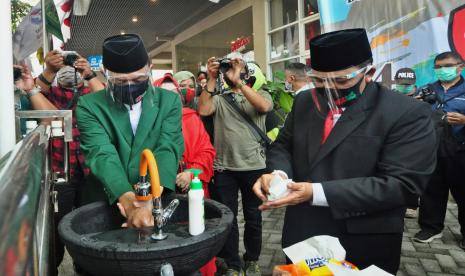 Pasangan bakal calon bupati dan wakil bupati Semarang, Ngesti Nugraha- M Basari mencuci tangan di halaman kantor KPU Kabupaten Semarang, sebelum mendaftar di kantor penyelenggara pemilihan bupati dan wakil bupati Semarang tahun 2020 tersebut, Jumat (4/9). KPU Kabupaten Semarang memberlakukan protokol kesehatan ketat seperti wajib mencuci tangan, mengenakan masker dan face shield gun amencegah penyebaran Covid-19.