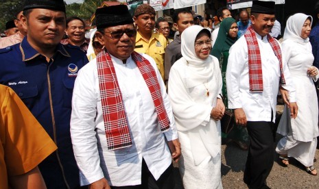 Pasangan bakal calon Gubernur/Wakil Gubernur Sumbar, Muslim Kasim (kedua kiri) dan Fauzi Bahar (kedua kanan), berjalan menuju kantor KPU Sumbar untuk mendaftar, di Padang, Selasa (28/7).