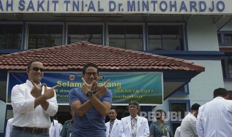 Pasangan Cagub dan Cawagub DKI Jakarta Anies Baswedan (kiri) dan Sandiaga Uno (kedua kiri) berpose saat tiba sebelum menjalani tes kesehatan di RSAL Mintohardjo, Jakarta, Sabtu (24/9). 