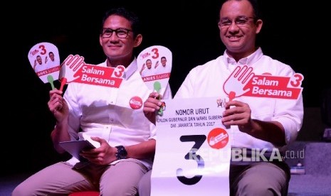   Pasangan Calon Gubernur dan Wakil Gubernur DKI Jakarta Anies Baswedan-Sandiaga Uno menunjukan nomor urut saat rapat pleno pengundian nomor urut pasangan calon gubernur dan wakil gubernur di Jakarta, Selasa (25/10) malam. (Republika/Prayogi)