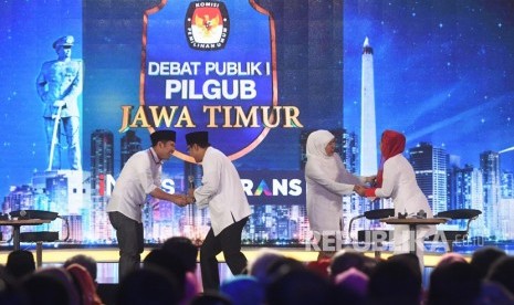 Pasangan calon Gubernur dan Wakil Gubernur Jawa Timur nomor urut satu Khofifah Indar Parawansa (kedua kanan)-Emil Dardak (kiri) dan nomor urut dua Saifullah Yusuf (kedua kiri)-Puti Guntur Soekarno (kanan) saling bersalaman ketika Debat Publik I Pilgub Jatim di Gedung Dyandra Convetion Center, Surabaya, Jawa Timur, Selasa (10/4).