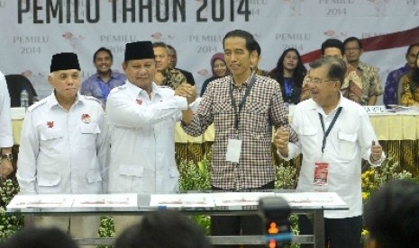 Pasangan calon presiden dan wakil presiden Joko Widodo (kedua kanan) dan Jusuf Kalla (kanan) beserta pasangan calon presiden dan wakil presiden Prabowo Subianto (kedua kiri) dan Hatta Rajasa (kiri) berjabat tangan usai pengundian dan penetapan nomor urut p