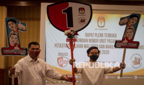 Pasangan Calon Wali Kota dan Wakil Wali Kota Solo dari Partai PDI Perjuangan, Gibran Rakabuming Raka (kanan) dan Teguh Prakosa (kiri) menunjukan poster nomor urut satu usai acara Rapat Pleno Komisi Pemilihan Umum (KPU) Pengundian Nomor Urut Peserta Pemilihan Wali Kota dan Wakil Wali Kota Solo 