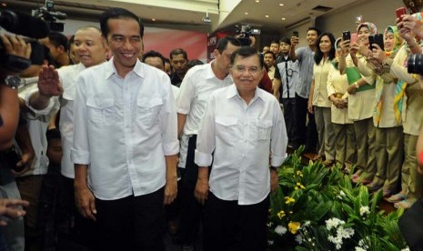 Pasangan Capres-cawapres PDIP Joko Widodo (kiri) dan Jusuf Kalla (kanan) berjalan saat mendatangi Komisi Pemilihan Umum (KPU) di Jakarta, Senin (19/5).