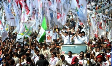 Pasangan Capres dan Cawapres nomor urut 1 Prabowo serta Hatta Rajasa melambaikan tangan menyapa simpatisan saat masuk area Kampanye Akbar di Gelora Bung Karno, Jakarta, Ahad (22/6).