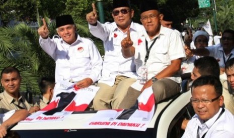 Pasangan Capres Prabowo Subianto (tengah) didampingi Cawapres Hatta Rajasa (kiri) dan Ketua Umum Partai Golkar Aburizal Bakrie (kanan) diarak saat keluar dari Gedung Komisi Pemilihan Umum (KPU) usai pengambilan nomor urut Pilpres 2014, Jakarta, Ahad (1/6).