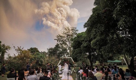 Pasangan di Filipina melaksanakan pernikahannya dengan latar letusan Gunung Taal, Batangas Filipina, Sementara  pernikahan berlangsung di Alfonso, Cavite, Philippines, January 12, 2020, in this image obtained from social media. 