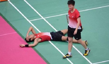 Pasangan ganda campuran bulutangkis Indonesia, Tontowi Ahmad (tiduran) dan Liliyana Natsir (berdiri) meratapi kegagalan menyumbang medali di ajang Olimpiade London 2012.