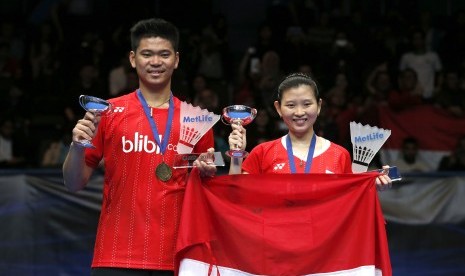 Pasangan ganda campuran Indonesia Debby Susanto (kanan) dan Praveen Jordan memegang piala setelah memenangi final ganda campuran di Kejuaraan Bulutangkis All England di Barclaycard Arena, Birmingham, Minggu (13/3)