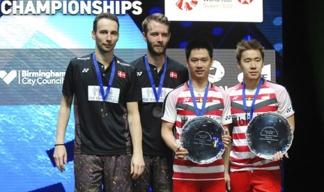 Pasangan ganda putra Indonesia, Marcus Fernaldi Gideon/Kevin Sanjaya Sukamuljo (kanan) di podium juara All England 2018, Ahad (18/3).