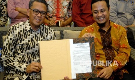 Pasangan Gubernur dan Wakil Gubernur Sulsel terpilih Nurdin Abdullah (kiri) dan Sudirman Sulaiman (kanan) memperlihatkan berita acara seusai rapat pleno terbuka penetapan pasangan calon terpilih Pilkada Sulsel 2018 di Makassar, Sulawesi Selatan, Kamis (26/7). 