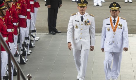 Pasangan Gubernur dan Wakil Gubernur terpilih Jambi, Zumi Zola Zulkifli (kiri) dan Fachrori Umar (kanan) berjalan menuju Istana Merdeka untuk menerima petikan Keppres dari Presiden Joko Widodo di Jakarta, Jumat (12/2). 