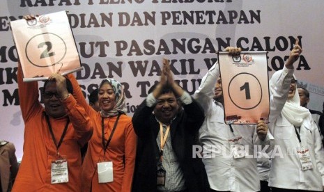 Pasangan Moh Ramdhan Pomanto (kiri)-Indira Mulyasari Paramastuti (dua kiri) dan pasangan Munafri Arifuddin (dua kanan)-Andi Rachmatika Dewi (kanan) didampingi ketua Komisi Pemilihan Umum (KPU) kota Makassar Syarief Amir (tengah) mengambil nomor urut pada rapat pleno penetapan nomor urut pasangan calon wali kota dan wakil wali kota Makassar di Makassar, Sulawesi Selatan, Selasa (13/2). 