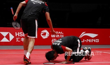 Pasangan Mohammad Ahsan (kanan) dan Hendra Setiawan merayakan kemenangan pada laga final nomor ganda putra melawan pasangan Jepang Hiroyuki Endo dan Yuta Watanabe pada turnamen World Tour Finals di Guangzhou, China, Ahad (15/12) 