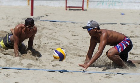 Pasangan pebola voli pantai Indonesia Danang Syah (kiri) dan Gilang Ramadhan berusaha mengembalikan bola saat mengikuti pelatnas  di Lapangan Voli Pantai Kawasan Gtadion Utama Gelora Bung Karno, Senayan, Jakarta, Senin (15/2)