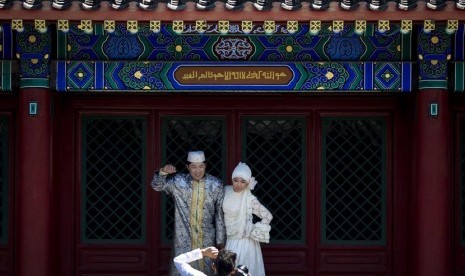 Pasangan pengantin baru berpose untuk difoto di Masjid Niujie, Beijing, Selasa (16/7).(AP/Andy Wong)