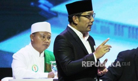 Pasangan Ridwan Kamil dan Uu Ruzhanul Ulum menyampaikan paparannya saat Debat Publik Pertama Pilgub Jawa Barat 2018 bersama empat pasangan calon gubernur dan wakil gubernur Jawa Barat, di Gedung Sabuga, Kota Bandung, Senin (12/3). 