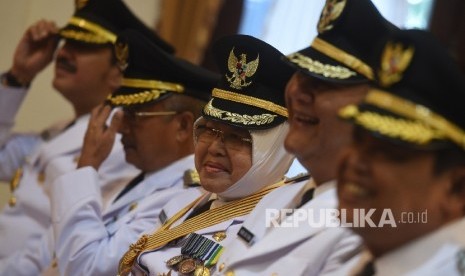 Pasangan Wali Kota/Wakil Wali Kota Surabaya terpilih Tri Rismaharini (tengah) dan Wisnu Sakti Buana (kedua kanan) tersenyum bersama sejumlah bupati/wakil bupati terpilih lainnya ketika mengikuti pelantikan gelombang