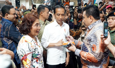 Pasar Ikan Muara Baru. Presiden Jokowi didampingi Menteri Kelautan dan Perikanan Susi Pudjiastuti menjajal mesin EDC BNI.