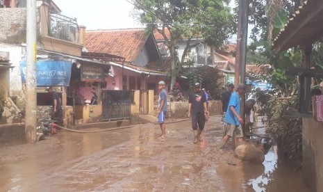 Pasca banjir, puluhan warga di Kelurahan Andir, Kecamatan Baleendah mulai membersihkan sisa lumpur yang terbawa banjir di jalan Andir-Katapang dan pemukiman warga, Selasa (12/3).