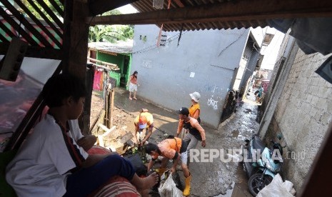 Petugas Penanganan Prasarana dan Sarana Umum membersihkan sampah pasca banjir yang diakibatkan tanggul jebol di Jatipadang, Pasar Minggu, Jakarta Selatan, Jumat (20/10).