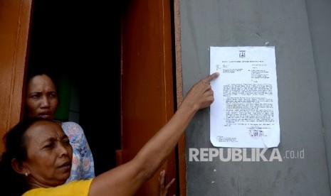 Kertas yang berisi surat sosialisasi penertiban Kalijodo dipasang pada tembok rumah warga di Kawasan Kalijodo, Jakarta, Senin (15/2).