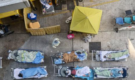  Pasien yang menunjukkan gejala Covid-19 berbaring di tempat tidur di luar Departemen Kecelakaan dan Gawat Darurat di Caritas Medical Center di Hong Kong, China, 15 Februari 2022. Sistem medis Hong Kong telah kelebihan beban oleh wabah Covid-19 gelombang kelima sementara pihak berwenang telah melaporkan lebih banyak dari 1.600 kasus terkonfirmasi dan 5.400 dugaan infeksi pada 15 Februari. 