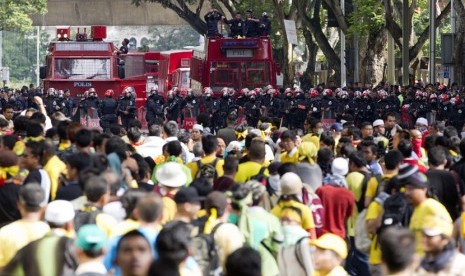  Pasukan anti huru-hara Malaysia menghadang kerumunan peserta aksi unjuk rasa di Kuala Lumpur, Malaysia, Sabtu (28/4).  (Mark Baker/AP)