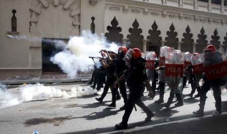 Pasukan anti huru hara menembakkan gas air mata ke arah massa pengunjuk rasa di Kuala Lumpur, Malaysia, Sabtu (28/4). 