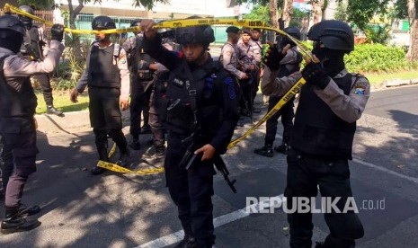 Pasukan Brimob memasang garis polisi di sekitar Gereja Santa Maria akibat serangan bom, Ahad (13/5).