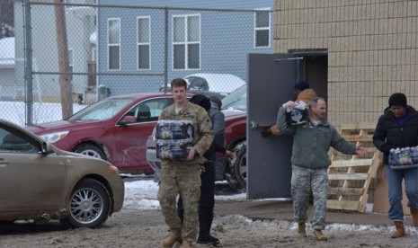 Pasukan Garda Nasional Amerika Serikat mendistribusikan air bagi warga Flint, Michigan, Jumat (16/1).