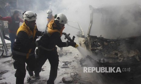 Pasukan Relawan Helm Putih  memadamkan api yang membakar sebuah kendaraan akibat serangan udara pasukan pemerintah di Kota  Ariha, Provinsi Idlib Suriah, Rabu (15/1).