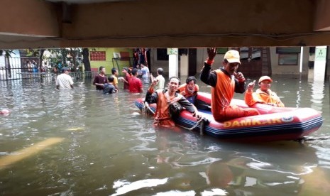 Pasukan oranye yang sedang bertugas di tengah banjir, Jumat (3/1). BNPB mencatat 53 orang meninggal akibat banjir yang melanda Jakarta, Jabar, Banten.