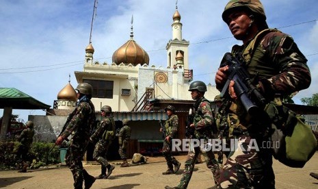 Pasukan pemerintah melintasi masjid di Marawi City, Filipina Selatan.