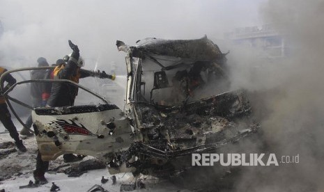 Pasukan Relawan Helm Putih  memadamkan api yang membakar sebuah kendaraan akibat serangan udara pasukan pemerintah di Kota  Ariha, Provinsi Idlib Suriah, Rabu (15/1).