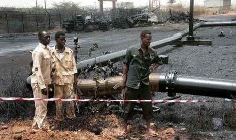  Pasukan Sudan mengamati pipa minyak yang terbakar akibat serangan bom di kota Heglig, Sudan, Kamis (24/4) lalu.