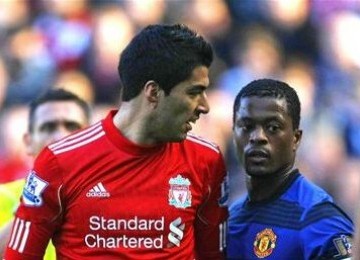 Patrice Evra, bek Manchester United, terlibat adu mulut dengan Luis Suarez (kiri), striker Liverpool, di laga Liga Primer di Anfield, Liverpool.