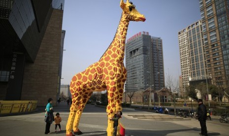 Patung jerapah dari legi berdiri di sebuah pusat perbelanjaan di Shanghai dalam rangka pembukaan toko terbesarnya di dunia.