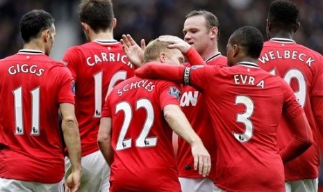 Paul Scholes (tengah) disalami rekannya usai menjebol gawang Queens Park Rangers di Stadion Old Trafford Stadium, Manchester, Ahad (8/4).