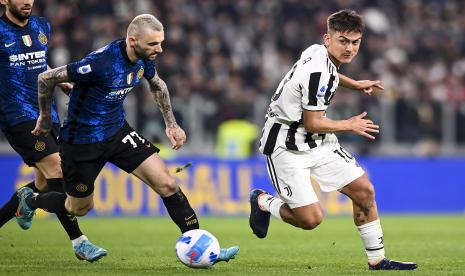 Paulo Dybala dari Juventus dan Marcelo Brozovic dari Inter Milan berebut bola selama pertandingan sepak bola Serie A antara Juventus dan Inter Milan, di stadion Allianz di Turin, Italia, Ahad, 3 April 2022.