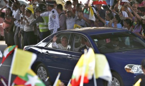 Paus Francis melambaikan tangan saat tiba di Yangon, Myanmar, Senin (27/11).